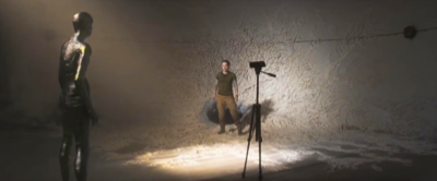 lena standing next to the hole that leads to the tunnel with a featureless silver shiny figure stares at her