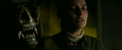 the skeletal face of a horrifying bear-like creature with huge teeth in massive jaws next to lena's face as she's bound to the chair