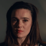 bronwyn, a woman with long straight brown hair and wearing red lipstick